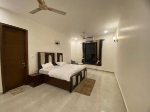 a bedroom with a bed and a ceiling fan at Mitron Farms in New Delhi