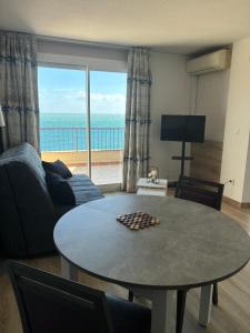 a living room with a table and a view of the ocean at sol appart hotel in Banyuls-sur-Mer