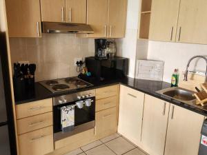 a small kitchen with a stove and a sink at 13 at Santos in Mossel Bay
