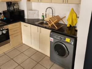 a kitchen with a washing machine and a sink at 13 at Santos in Mossel Bay