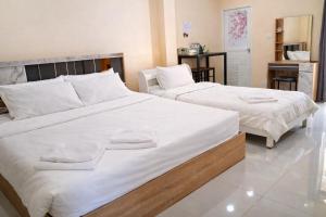 two large beds in a room with a kitchen at วลัญชญ์ โฮเทล ศรีราชา in Ban Nong Chaeng +3 photos
