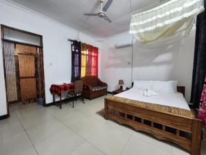 a bedroom with a bed and a chair and a table at MaTemu Square in Mapinga