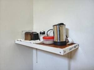 a shelf with pots and pans on a wall at MaTemu Square in Mapinga