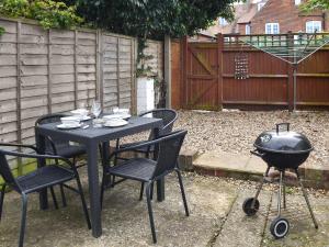 a black table and chairs with a grill and a bbq at Maydrift in Mundesley