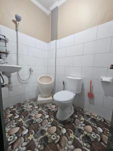 a bathroom with a toilet and a sink at Ibu ana quest house in Tabanan +41 photos