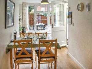 a dining room with a table and four chairs at Maydrift in Mundesley