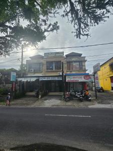 a building on the side of a street with motorcycles in front at Ibu ana quest house in Tabanan