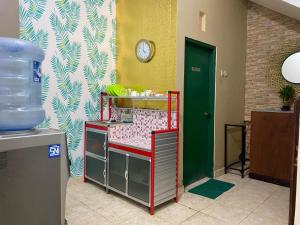 a room with a bed and a clock on a wall at Ibu ana quest house in Tabanan