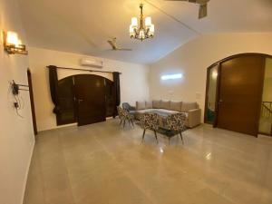 a living room with a table and chairs and a couch at Mitron Farms in New Delhi