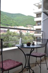 a table and two chairs on a balcony with a view at Yeshill Deluxe Apartment in Budva