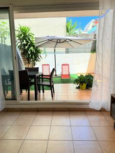 a patio with a table and chairs and an umbrella at Le Petit Oasis à Saint-Denis in Saint-Denis