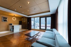 a living room with a blue couch and a table at 브라운도트호텔 인천 송도 Browndot Hotel Incheon Songdo in Incheon