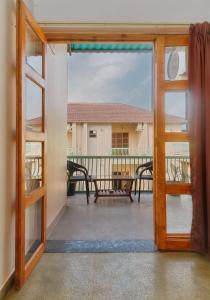 an open door to a balcony with a view of a house at The Bagh Villa Pench By Ficusroots Experience in Khawāsa