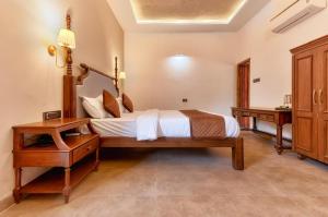 a bedroom with a large bed and a desk at The Bagh Villa Pench By Ficusroots Experience in Khawāsa +5 photos