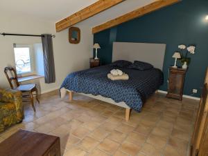 a bedroom with a bed with a blue wall at Gîte Le Mas du Colombeyras in Espeluche