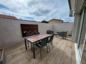 a patio with a table and chairs on a balcony at La grange d'augustin in Saint-Thibéry
