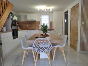 a kitchen with a wooden dining table and chairs at Le petit château de sable in Valras-Plage