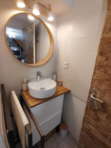 a bathroom with a sink and a mirror at Le petit château de sable in Valras-Plage