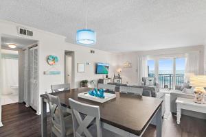 a dining room and living room with a view of the ocean at Emerald Isle 708 in Fort Walton Beach