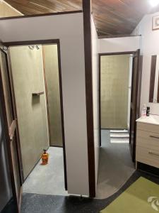 a bathroom with two glass doors and a sink at Leigh Backpackers in Leigh