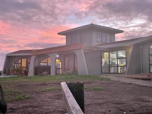 a house with a sunset in the background at Leigh Backpackers in Leigh