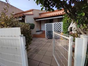 a white fence in front of a house at Le petit château de sable in Valras-Plage +3 photos