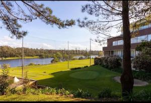 a golf course next to a building and a lake at Studio Luxury Quinta da Barca in Esposende