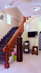 a staircase in a living room with a tv and a stair case at Angkor Sandra Villa in Siem Reap
