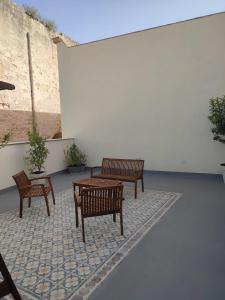 a patio with three benches and a table at Residenza San Giovannello in Marsala