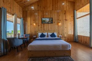 a bedroom with a bed and a table and chairs at The Golden Castle Hotels in Mukteshwar