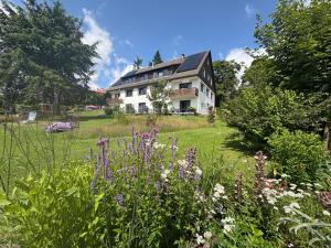 a house with a garden with flowers in front of it at Berghotel Hohegeiß in Hohegeiß