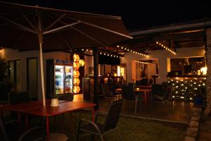 a restaurant with tables and chairs and an umbrella at Bougainvilla Kolwezi Guesthouse in Kolwezi +15 photos