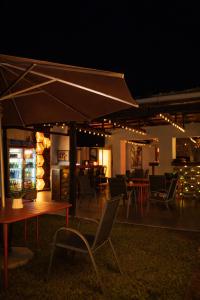 a patio with a table and chairs and an umbrella at Bougainvilla Kolwezi Guesthouse in Kolwezi