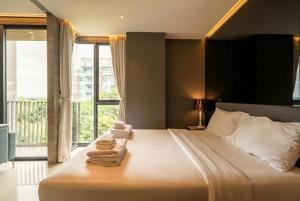 a bedroom with a large bed with towels on it at Seaphere Residence by Prop Hopper in Na Jomtien