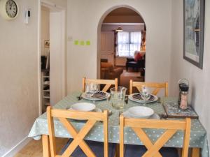 a dining room table with two chairs and a green table cloth at Maydrift in Mundesley +12 photos