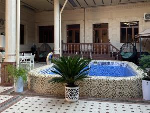 a pool on a house with a table and a plant at Hostel Azizjon in Samarkand