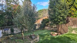 a backyard with a fence and a green yard at Gîte du caveau in Marcorignan