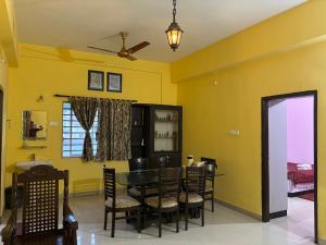 a dining room with yellow walls and a table and chairs at Tranquil Premium in Bhubaneshwar