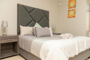 a bedroom with a large bed with a large headboard at Don Self Catering in Walvis Bay