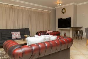 a living room with a leather couch and a table at Don Self Catering in Walvis Bay