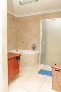 a bathroom with a bath tub and a sink at Don Self Catering in Walvis Bay +22 photos