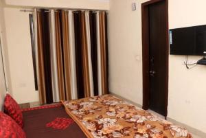 a bed in a room with a curtain and a television at The Gopi Dham Hotel in Haridwār +21 photos