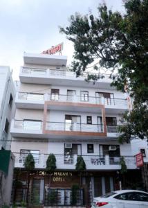 a white building with a sign on top of it at The Gopi Dham Hotel in Haridwār