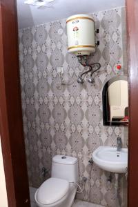 a bathroom with a toilet and a sink at The Gopi Dham Hotel in Haridwār