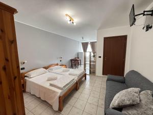 a bedroom with a bed and a couch at Agriturismo San Giuliano dei fratelli Giai in Susa