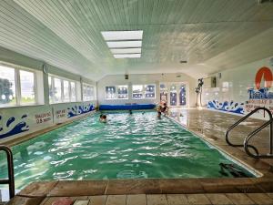 a group of people swimming in a swimming pool at The Canny View at Three Lochs Holiday Park in Balminnoch 3 bedroom sleeps upto 8 guests in Newton Stewart