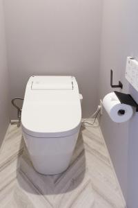 a white toilet in a bathroom with a toilet paper roll at precious days inn in Fukuoka