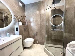 a bathroom with a shower and a toilet and a sink at Апартаменти Парус Сіті in Lviv +18 photos
