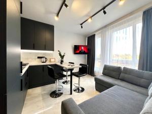 a kitchen and living room with a couch and a table at Апартаменти Парус Сіті in Lviv