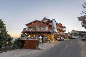 a large wooden building on the side of a street at The Golden Castle Hotels in Mukteshwar